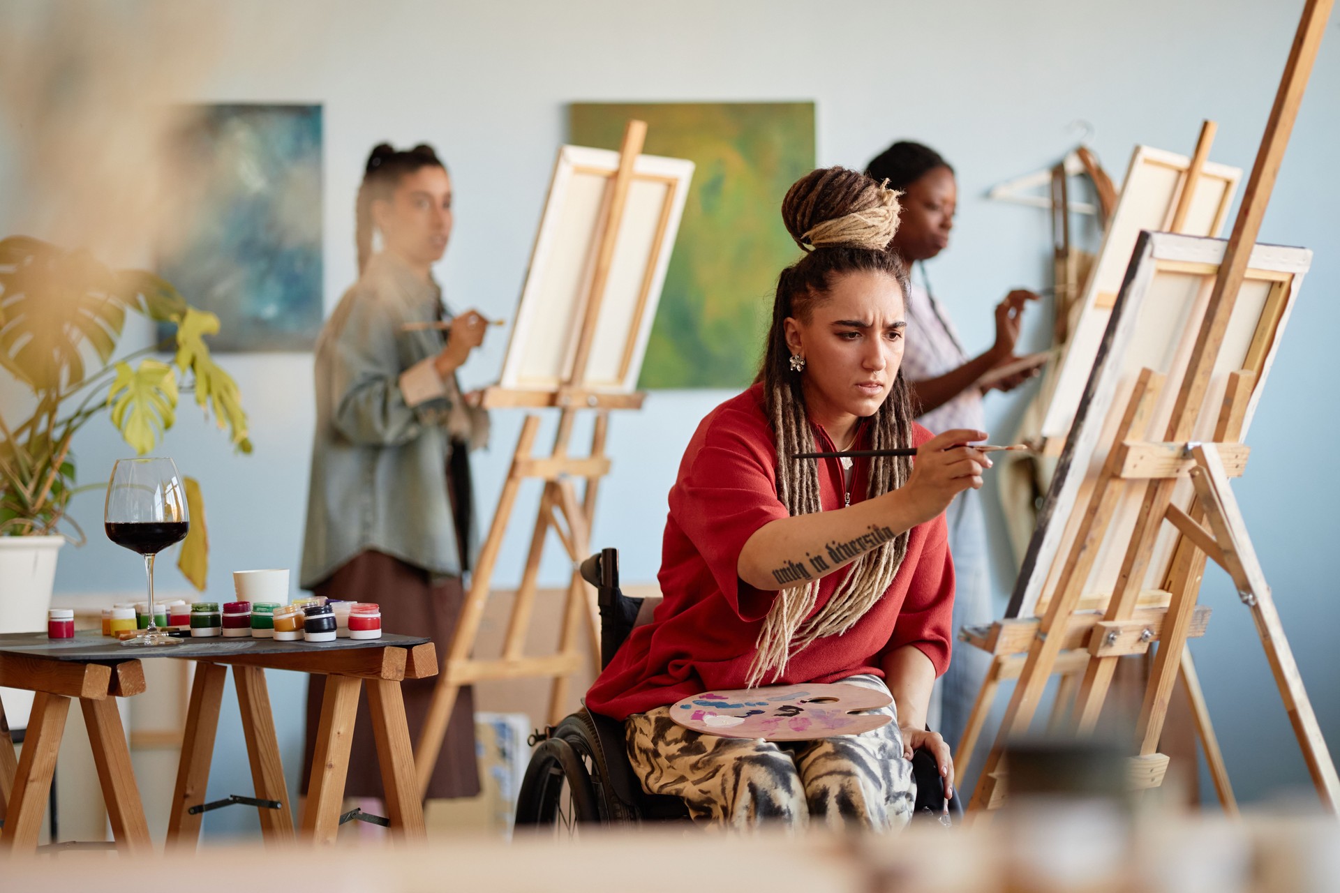 Young Adult Caucasian Woman with Disability Concentrating on Painting in Studio